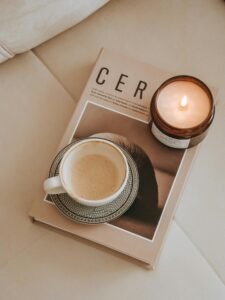 Cozy minimalist setup with a cup of coffee and a lit candle on a tray, creating a warm and inviting atmosphere for home relaxation.
