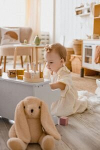 Young child playing with a stuffed bunny in a sunlit living room, showcasing a cozy, playful, and family-friendly home environment.