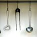 Minimalist kitchen utensils hanging on a metal rod, including a spatula, whisk, tongs, ladle, and pasta server, styled against a neutral wall for an organized, cozy, and functional kitchen aesthetic.