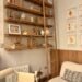 Cozy reading nook corner with wooden ladder bookshelf, neutral decor, framed art, and soft seating, styled to create a warm and inviting reading space