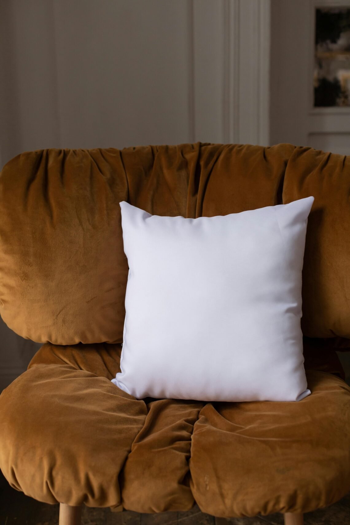 Warm brown accent chair with plush white pillow, styled in a cozy home corner for comfortable reading and relaxing
