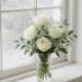 Fresh white roses in a clear glass vase on a windowsill, brightening a cozy home environment and adding elegant natural decor to indoor spaces