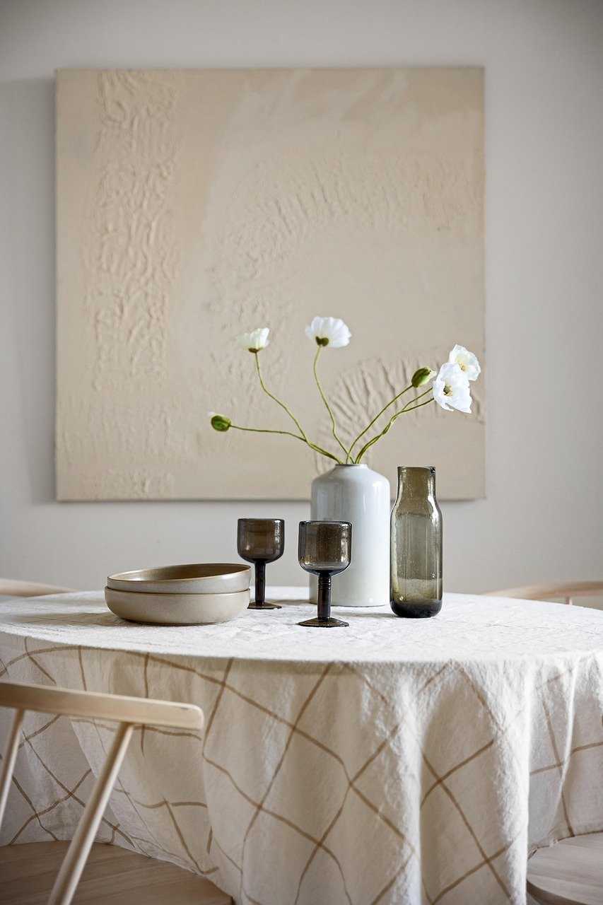 “Calm and cozy home decor table setup with neutral tones, minimalist vases, and soft natural accents for a serene and inviting living space.