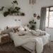 A cozy minimal bedroom with soft neutral bedding, layered blankets, and warm lighting. Natural textures, wood accents, and indoor plants create a calm, inviting retreat that perfectly captures warm minimal bedroom styling.