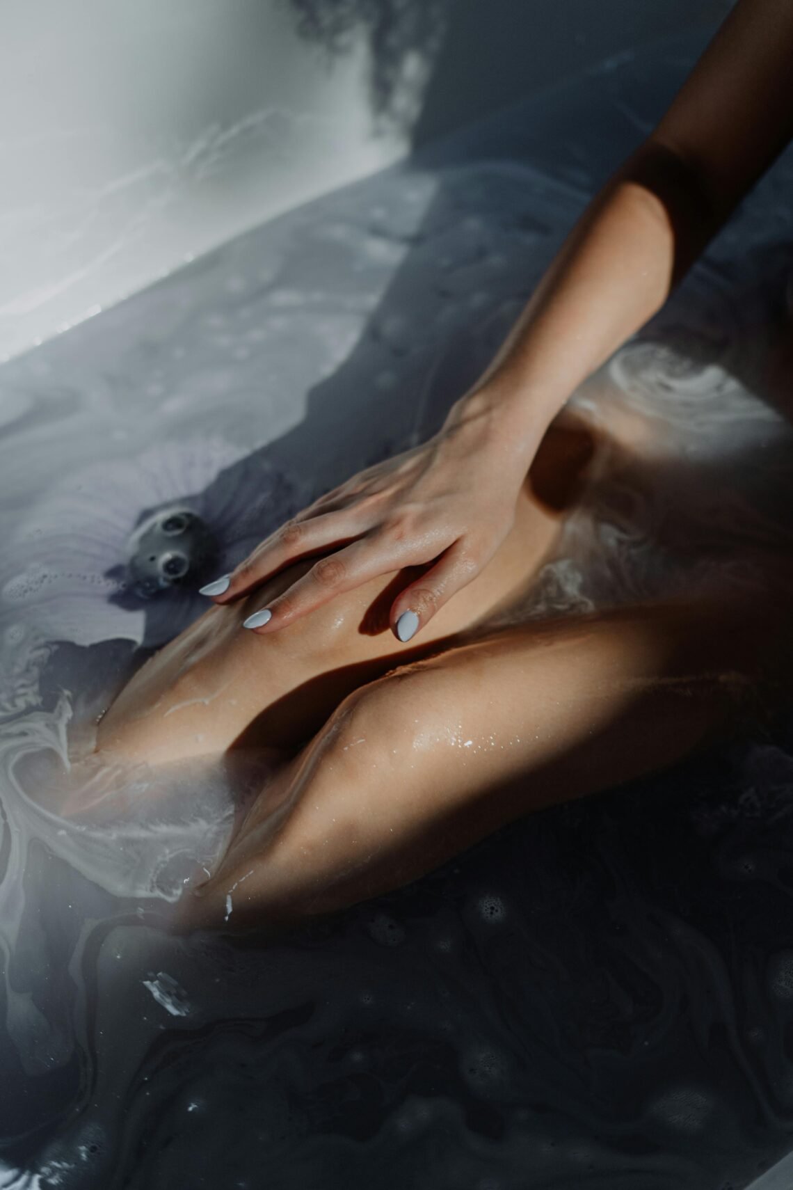A woman resting quietly in a warm bath with soft lighting, creating a peaceful self care moment ideal for easing social exhaustion and calming an overwhelmed mind.
