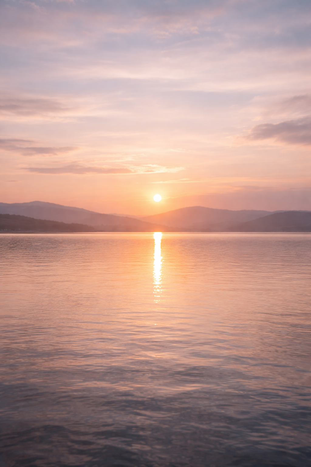 soft pastel sunrise over calm lake water with gentle ripples and muted clouds creating a peaceful minimalist scene that evokes quiet mornings slow living and intentional calm