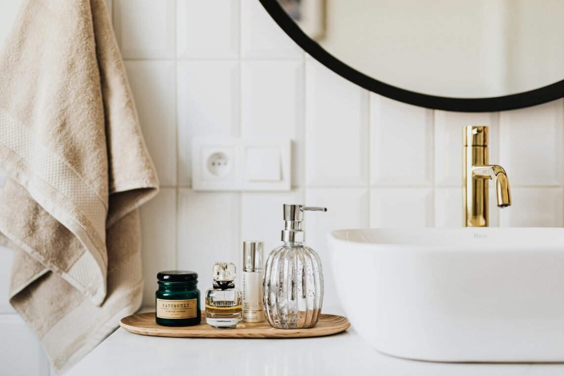 smart bathroom upgrades featuring modern sink with gold faucet neutral soap dispenser towel and minimalist bathroom accessories for a clean safe bathroom