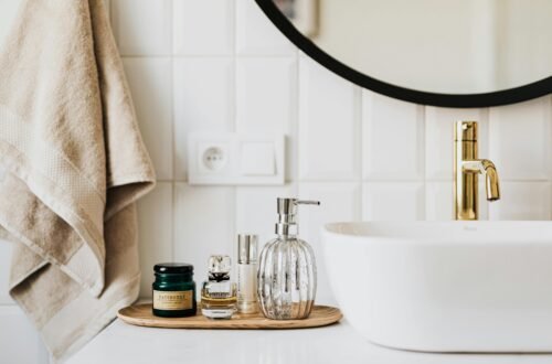 smart bathroom upgrades featuring modern sink with gold faucet neutral soap dispenser towel and minimalist bathroom accessories for a clean safe bathroom