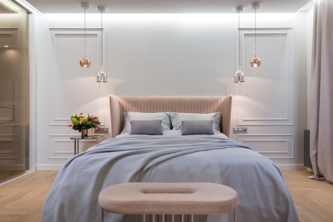 Luxury hotel inspired bedroom featuring a soft upholstered bed, warm pendant lighting, neutral decor, and calming Amazon bedroom finds for a cozy, elegant space